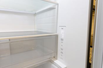 A white refrigerator with the temperature control set to 37 degrees.